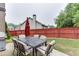 Backyard featuring a patio with outdoor furniture, a grill, and a red privacy fence at 893 Whitfield Oak Rd, Auburn, GA 30011