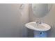 Neat half bathroom with pedestal sink, round mirror, and modern fixtures at 12039 Quail Dr, Hampton, GA 30228