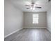 This bedroom features neutral walls, ceiling fan, window, and wood-look flooring at 12039 Quail Dr, Hampton, GA 30228