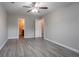 This bedroom features neutral walls, ceiling fan, light hardwood floor, and a door that opens to a bathroom at 12039 Quail Dr, Hampton, GA 30228
