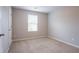 Empty bedroom with neutral carpet, a window, and a door, ready for personalization at 12039 Quail Dr, Hampton, GA 30228