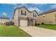 Two story home with neutral siding, black shutters, an attached garage, and a green lawn at 12039 Quail Dr, Hampton, GA 30228