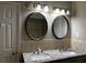 Bathroom vanity with dual sinks, granite counters, lighting, and mirrors at 2436 Glenrock Dr, Decatur, GA 30032
