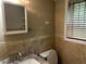 Bathroom featuring a tiled wall, a mirror, a window with blinds, and a toilet at 2436 Glenrock Dr, Decatur, GA 30032
