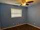 This bedroom features lovely blue walls, hardwood floors, and a ceiling fan at 2436 Glenrock Dr, Decatur, GA 30032