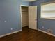 Bedroom featuring hardwood floors, a window with blinds, closet, and blue walls at 2436 Glenrock Dr, Decatur, GA 30032