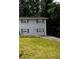 Two-story home with gray brick, dark shutters, and a driveway, nestled on a green hillside at 2436 Glenrock Dr, Decatur, GA 30032