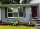 Home exterior showing the front door, window with shutters and landscaped garden bed at 2436 Glenrock Dr, Decatur, GA 30032