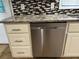 Kitchen with stainless steel dishwasher, granite countertops, white cabinets, and backsplash at 2436 Glenrock Dr, Decatur, GA 30032