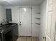 A laundry room with a washing machine, tiled floor, and an entry door at 2436 Glenrock Dr, Decatur, GA 30032