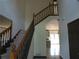 Inviting foyer with a grand staircase, neutral walls, and tiled flooring, leading to the kitchen at 4576 Creek Forestt Trl, Lilburn, GA 30047