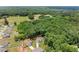 Aerial view of a community with a home nestled among the trees and adjacent to green fields at 65 Harmony Woods Ln, Dallas, GA 30157