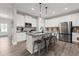 Modern kitchen showcasing white cabinets, stainless steel appliances, a granite island with seating, and hardwood floors at 65 Harmony Woods Ln, Dallas, GA 30157