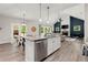 Open concept living area featuring a stone fireplace with tv, high ceilings, and a kitchen island with a stainless steel dishwasher at 65 Harmony Woods Ln, Dallas, GA 30157