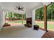 Covered patio with a stone fireplace, ceiling fan, and views of the landscaped backyard at 65 Harmony Woods Ln, Dallas, GA 30157