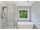 Elegant bathroom featuring a freestanding tub, walk-in shower, and patterned wallpaper at 1916 River Birch Ln, Atlanta, GA 30316