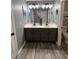 Bathroom features a double vanity with modern lighting, gray cabinets, and wood-look laminate flooring at 2030 Hydrangea Ln, Austell, GA 30106