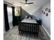 Bedroom with gray walls with geometric design, ceiling fan and light, and wood-look laminate flooring at 2030 Hydrangea Ln, Austell, GA 30106