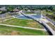 Aerial view showcasing a park with a pedestrian bridge, ponds, and green spaces for leisure and recreation at 3621 Portland Trail Dr, Suwanee, GA 30024