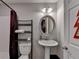 Classic bathroom with a pedestal sink, silver framed mirror, and modern shelving at 3621 Portland Trail Dr, Suwanee, GA 30024