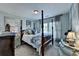 Bedroom boasts a four-poster bed, soft blue walls, carpet, and window light at 3621 Portland Trail Dr, Suwanee, GA 30024