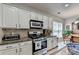 Modern kitchen with granite counters, stainless steel appliances, and white cabinets at 3621 Portland Trail Dr, Suwanee, GA 30024