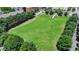 Aerial view of a large grassy open space surrounded by trees and buildings in a community at 3621 Portland Trail Dr, Suwanee, GA 30024