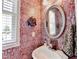 Quaint powder room with unique wallpaper and a decorative mirror at 3621 Portland Trail Dr, Suwanee, GA 30024