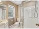 Well-lit bathroom showcasing a glass shower, updated toilet, and white marbled floors at 107 Mary Gay Ct, Decatur, GA 30030