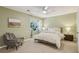 A bright bedroom with a ceiling fan, large window, and a chair with throw blanket at 107 Mary Gay Ct, Decatur, GA 30030