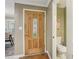 Stylish interior shot of a stained wood front door with glass panel, next to a half bathroom at 107 Mary Gay Ct, Decatur, GA 30030