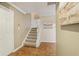 Hallway with wood floors leads to a carpeted staircase and white doors at 107 Mary Gay Ct, Decatur, GA 30030