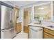 Stainless steel refrigerator and dishwasher complement the wood cabinets and white countertops at 107 Mary Gay Ct, Decatur, GA 30030