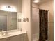 Well-lit bathroom with white cabinets, a sleek vanity, a large mirror, and shower/tub combo at 1301 Haven Cir, Douglasville, GA 30135