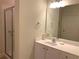 Well-lit bathroom with white cabinets, a sleek vanity, a large mirror, and glass-enclosed shower at 1301 Haven Cir, Douglasville, GA 30135