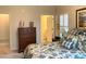 Cozy bedroom features a floral comforter, wood dresser, and access to a bright, neutral ensuite bathroom at 1301 Haven Cir, Douglasville, GA 30135