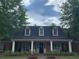 Charming brick home features a welcoming front porch, complemented by lush landscaping and mature trees at 1301 Haven Cir, Douglasville, GA 30135