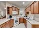 Well-lit kitchen featuring white appliances, wood cabinets and neutral countertops at 1301 Haven Cir, Douglasville, GA 30135