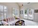 Light-filled sitting room featuring a comfortable couch, shuttered windows and access to a patio at 1301 Haven Cir, Douglasville, GA 30135