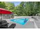 Beautiful in-ground pool surrounded by mature trees and lounge chairs at 5219 Legendary Ln, Acworth, GA 30102
