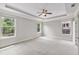 Spacious bedroom featuring tray ceiling, fan, and ample natural light from large windows at 1374 Highland Wood Ct, Auburn, GA 30011