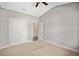 Carpeted bedroom features closet access, high ceilings and ceiling fan at 1374 Highland Wood Ct, Auburn, GA 30011