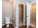 Half bathroom with wood look floors, toilet, and closet with wire shelving at 208 Oconee Way, Canton, GA 30114