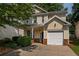 Charming two-story home with a well-maintained lawn, attached garage, and inviting front porch at 208 Oconee Way, Canton, GA 30114