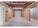 Unfinished basement featuring a garage door and concrete flooring at 260 Pleasant Grove Cir, Mcdonough, GA 30252
