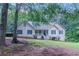 Charming one-story home with a well-manicured lawn and inviting front porch surrounded by mature trees at 260 Pleasant Grove Cir, Mcdonough, GA 30252