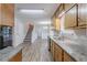 Galley style kitchen featuring granite countertops, stainless steel appliances, and stylish vinyl plank flooring at 260 Pleasant Grove Cir, Mcdonough, GA 30252
