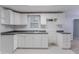 Well-lit kitchen with white cabinets and black and white patterned tile floor offering a modern look at 260 Pleasant Grove Cir, Mcdonough, GA 30252