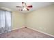 Bright, empty bedroom featuring neutral walls, carpeted floor, window with natural light, and ceiling fan at 502 Gallantry Trl, Mcdonough, GA 30252