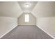 Expansive carpeted bonus room with angled ceilings and a window, ideal for a playroom or extra storage at 502 Gallantry Trl, Mcdonough, GA 30252